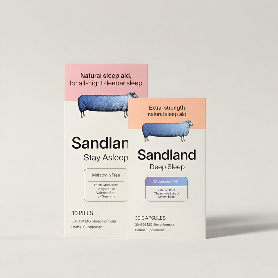 Two product boxes for Sandland sleep aids on a light gray background. The front box is Sandland Stay Asleep with a pink header and blue sheep illustration, and the rear box is Sandland Deep Sleep with an orange header and blue sheep illustration.